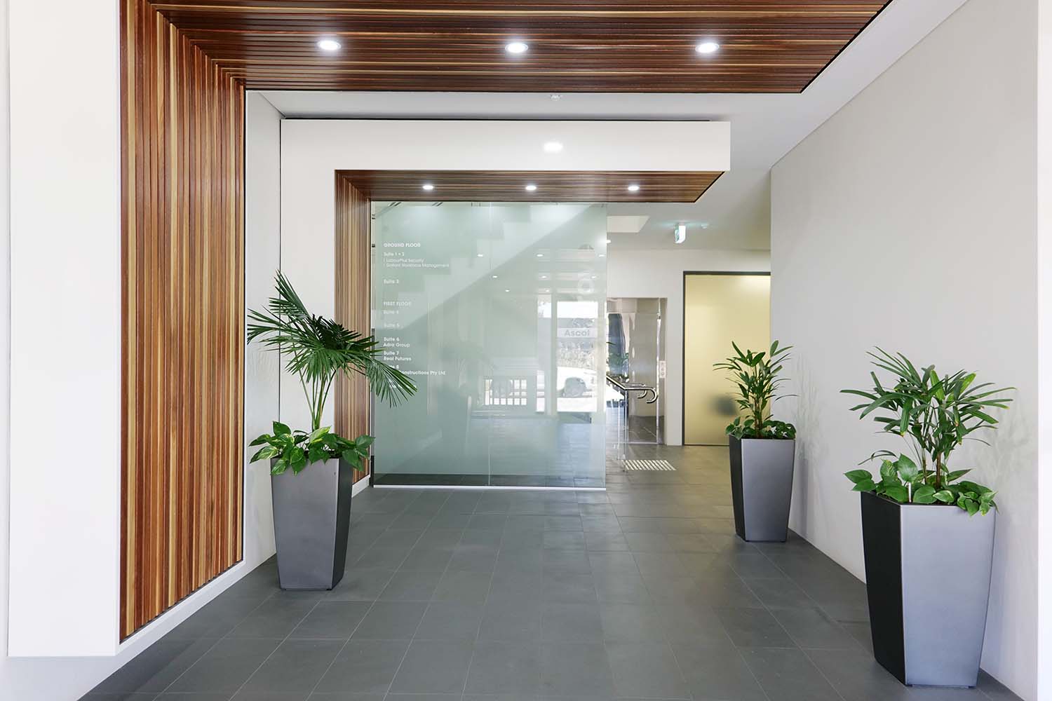 Interior of an office property in Burswood, Perth featuring felt cubicles and a white desk with blue walls.