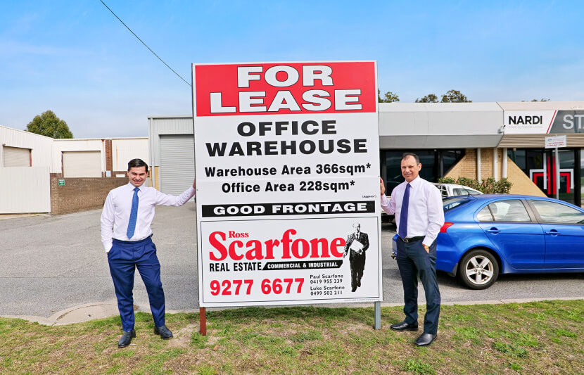 Commercial property experts Paul and Luke Scarfone standing beside a ‘For Lease’ sign in Perth.
